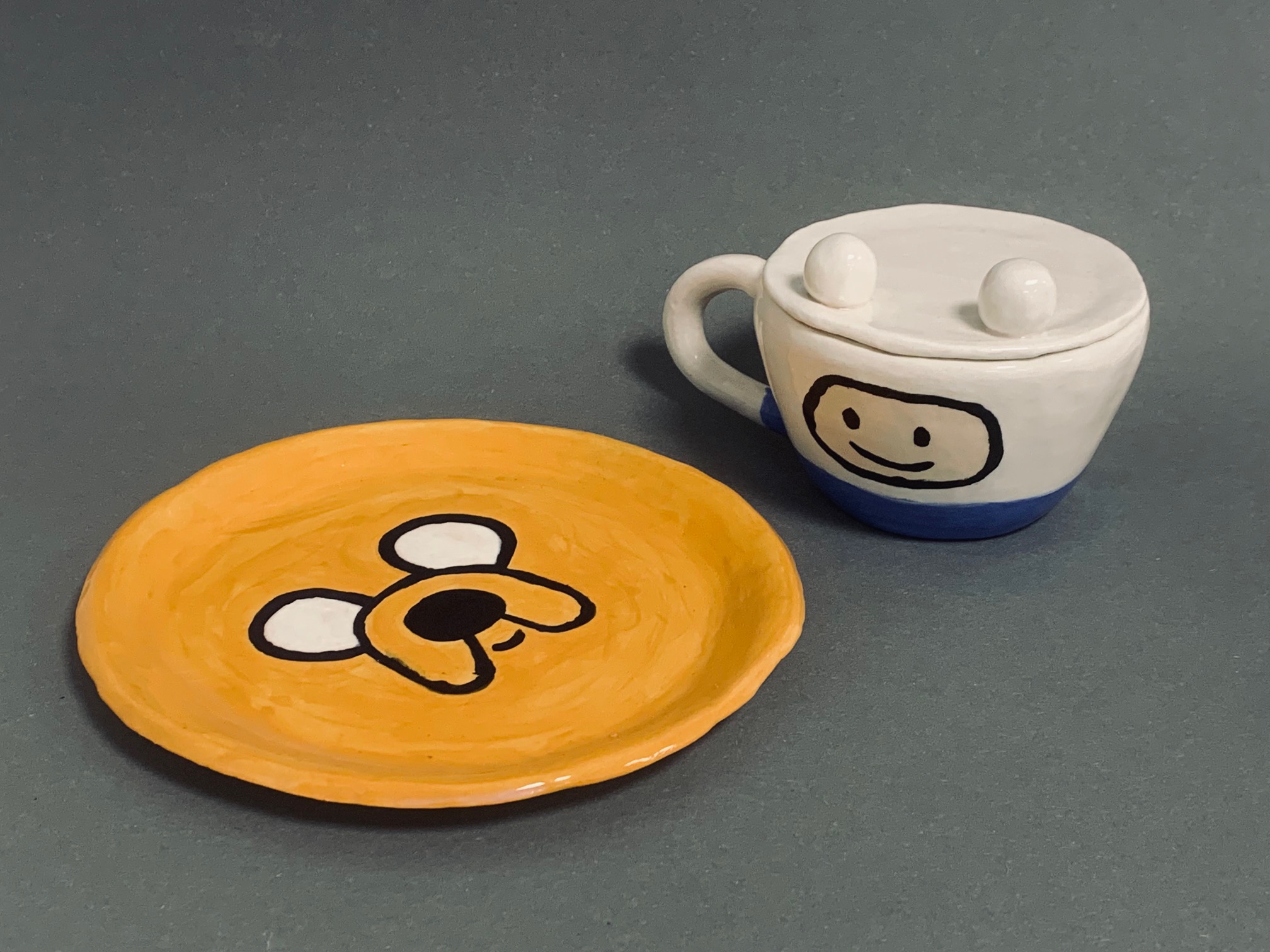 en tallerken med en kopp og et krus på den